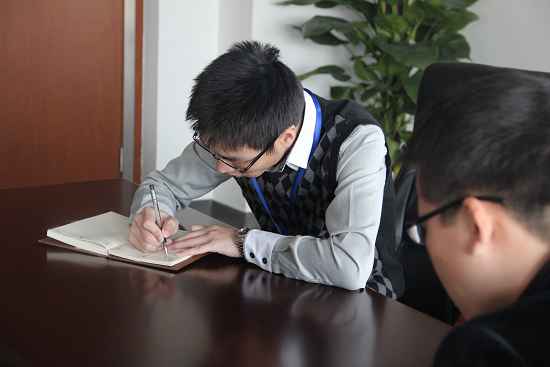 早會上朱總認真聆聽並記錄各部門匯報（bào）的工作情況